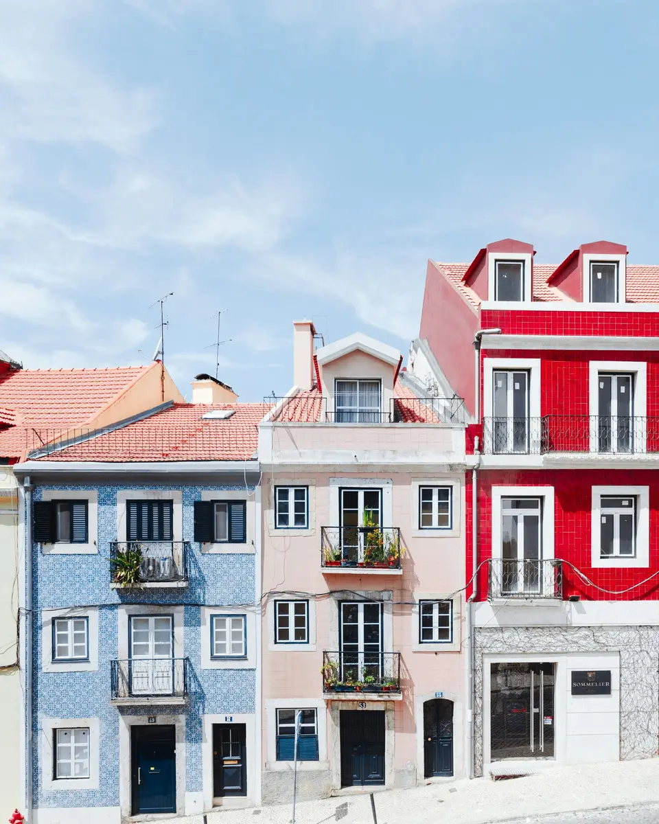 A sloping street of tiled houses in Lisbon, in late afternoon light